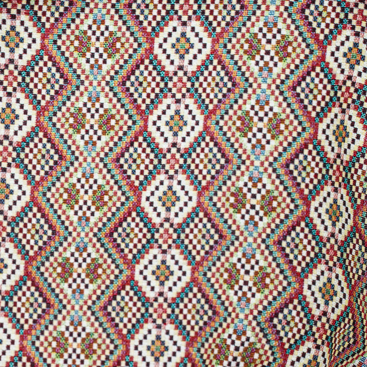 Experience the rich, traditional look of the Geometric Jacquard Coin Purse – Red Multicolor (Otto) by DE LA MUR LINE US Inc, crafted in Barcelona from vibrant woven jacquard fabric featuring symmetrical and intricate geometric diamond patterns in red, blue, yellow, green, and white—perfect for a unique accessory.