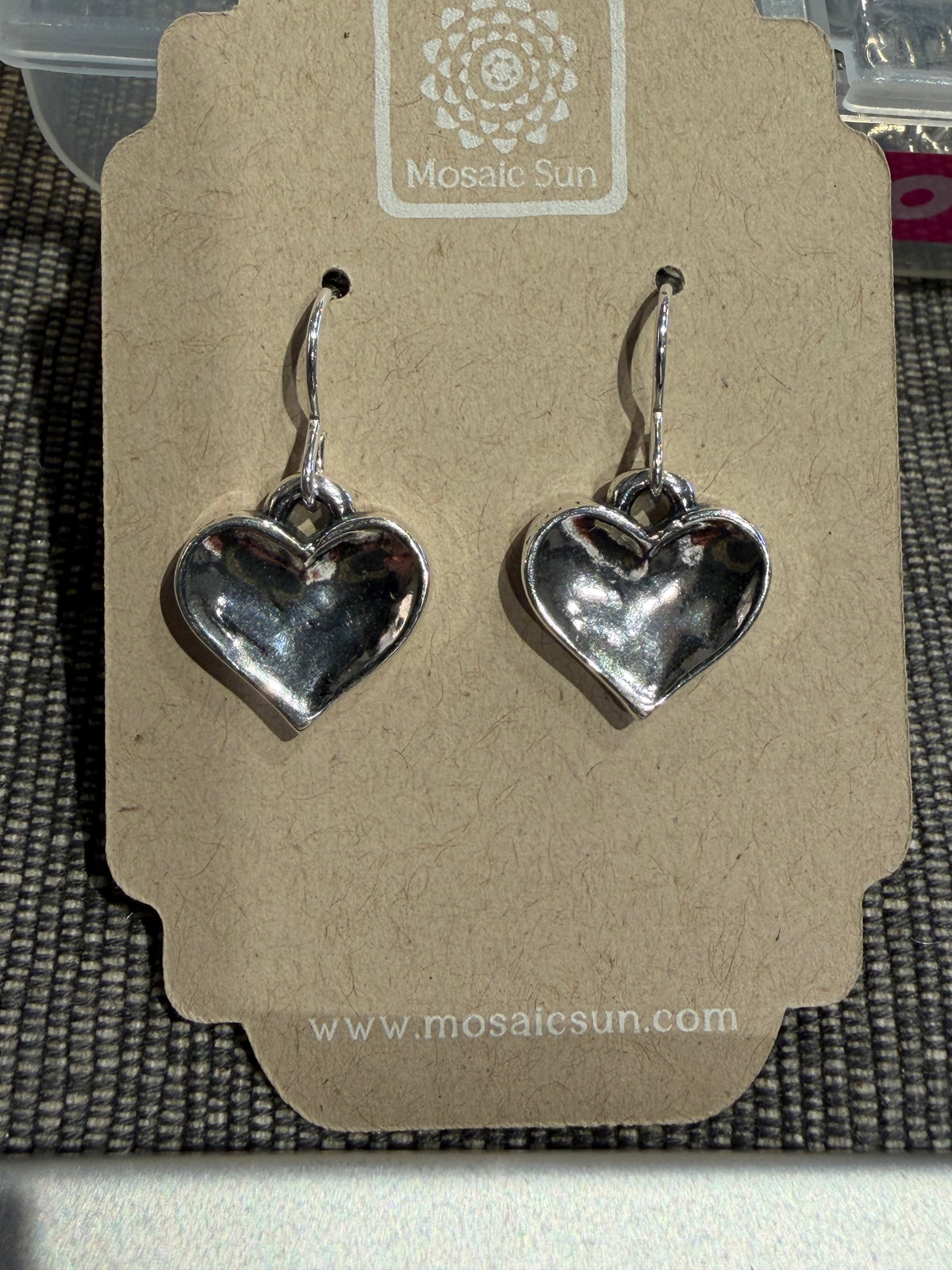 Dimpled Heart Earrings - Sterling hammered heart-shaped drop earrings on a cardboard display card.