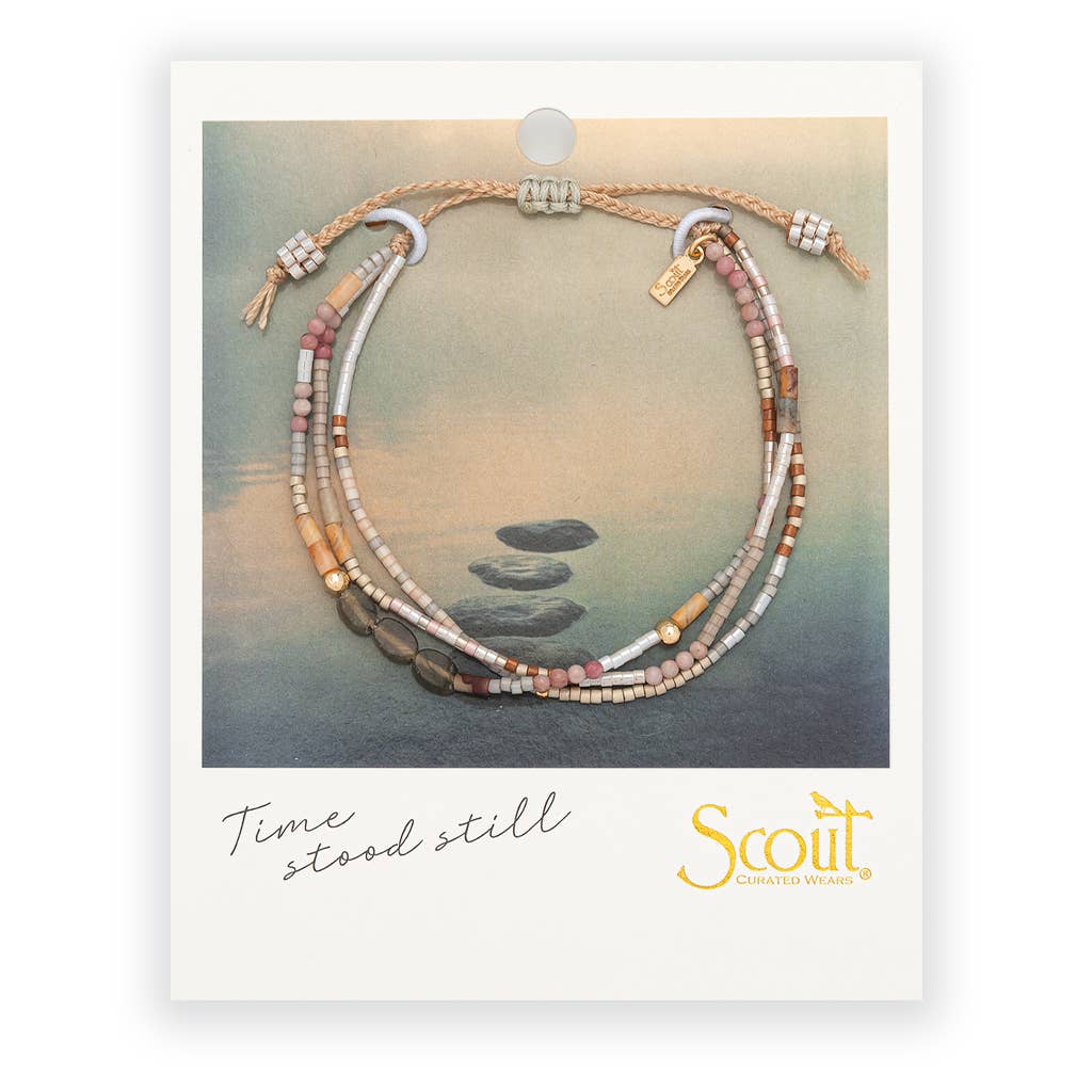 Mixed Media Bracelet – Magic/Labradorite/Gold featuring earth-tone Miyuki beads on a neutral cord, displayed on a card with stacked stones on water.