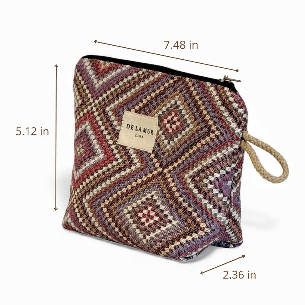 Introducing the Geometric Jacquard Small Makeup Bag – Pink & Lilac (Nana) by DE LA MUR LINE US Inc: This stylish pouch features a bold geometric kilim jacquard pattern in pink and lilac tones, accented with a rope loop. Measuring 7.48″ wide, 5.12″ tall, and 2.36″ deep, it’s adorned with the signature De La Mur Life label on the front—making it the perfect unique makeup bag or chic accessory organizer.