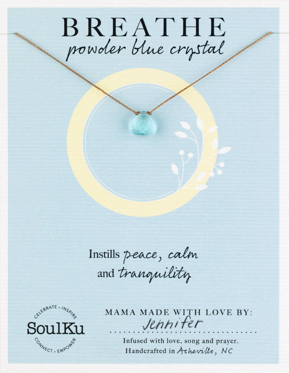 A faceted, light blue crystal necklace pendant from the SoulKu Powder Blue Crystal Necklace Gift for Breathe - Self Care hangs on a thin cord against a display card that reads BREATHE and Instills peace, calm and tranquility.