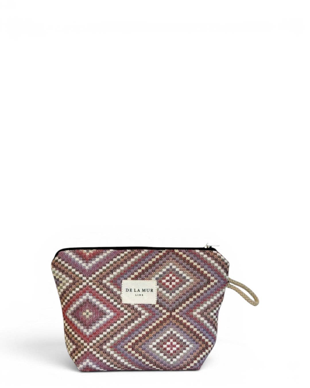The Geometric Jacquard Small Makeup Bag – Pink & Lilac (Nana) by DE LA MUR LINE US Inc features a zippered closure and showcases a geometric kilim diamond pattern in red, pink, brown, and cream tones. Accented with a small DE LA MUR label on the front and a convenient loop handle on the right side, this pouch is perfect as a stylish makeup bag.