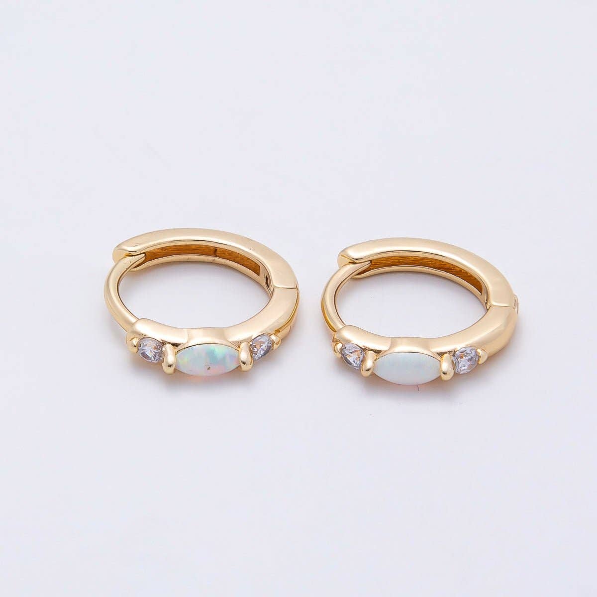 Aim Eternal Gold Filled 13mm White Opal/CZ Huggie Hoops featuring a central white opal flanked by two small clear stones.