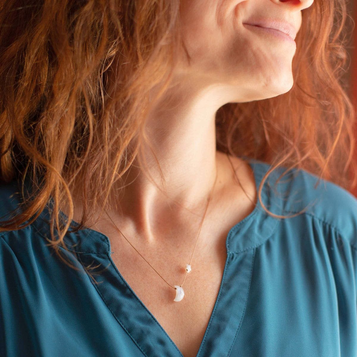 A delicate gold Moonstone I Love You To The Moon & Back necklace featuring a small crescent pendant and a single tiny bead.