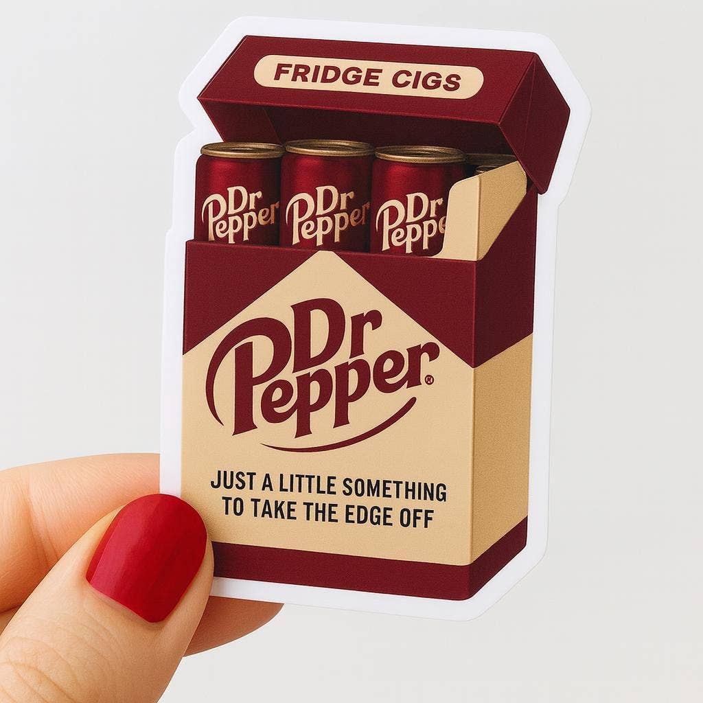 A hand with red nails holds a weather-resistant Dr Pepper Fridge Cigs Sticker by Hello Brand | Sticker My Art, featuring a mini Dr Pepper can pack designed to look like a box of cigarettes.