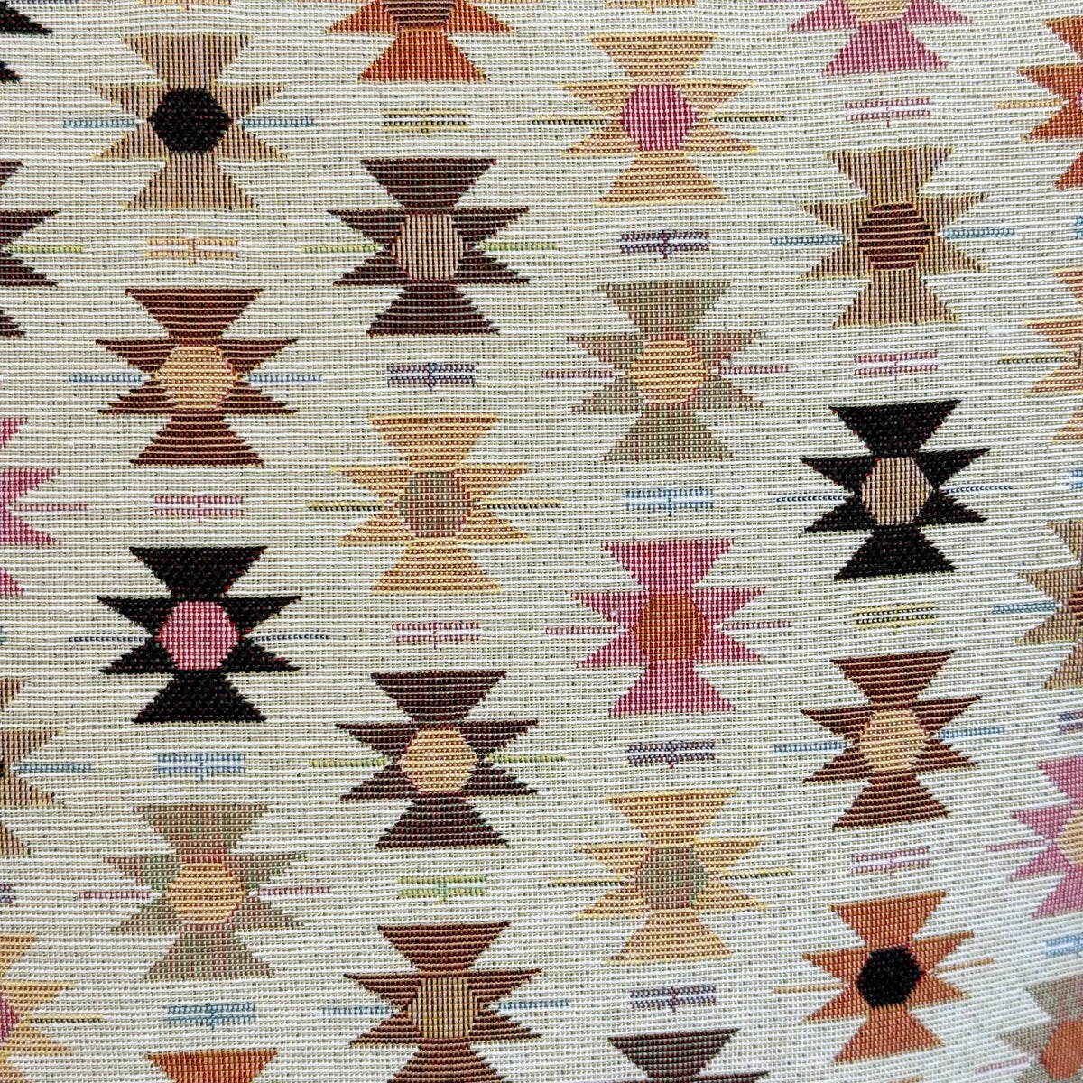 The Geometric Jacquard Small Makeup Bag – Pink & Orange (Royal) by DE LA MUR LINE US Inc features a jacquard fabric adorned with rows of geometric star motifs in pink, brown, black, and tan on a light background. Each star displays a central circle with radiating lines, forming a symmetrical and repeating Aztec-inspired pattern.