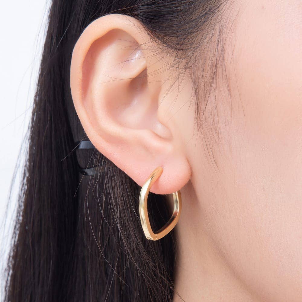 Gold-colored 25mm Square Huggie Hoop Earrings by Aim Eternal worn in an earlobe.