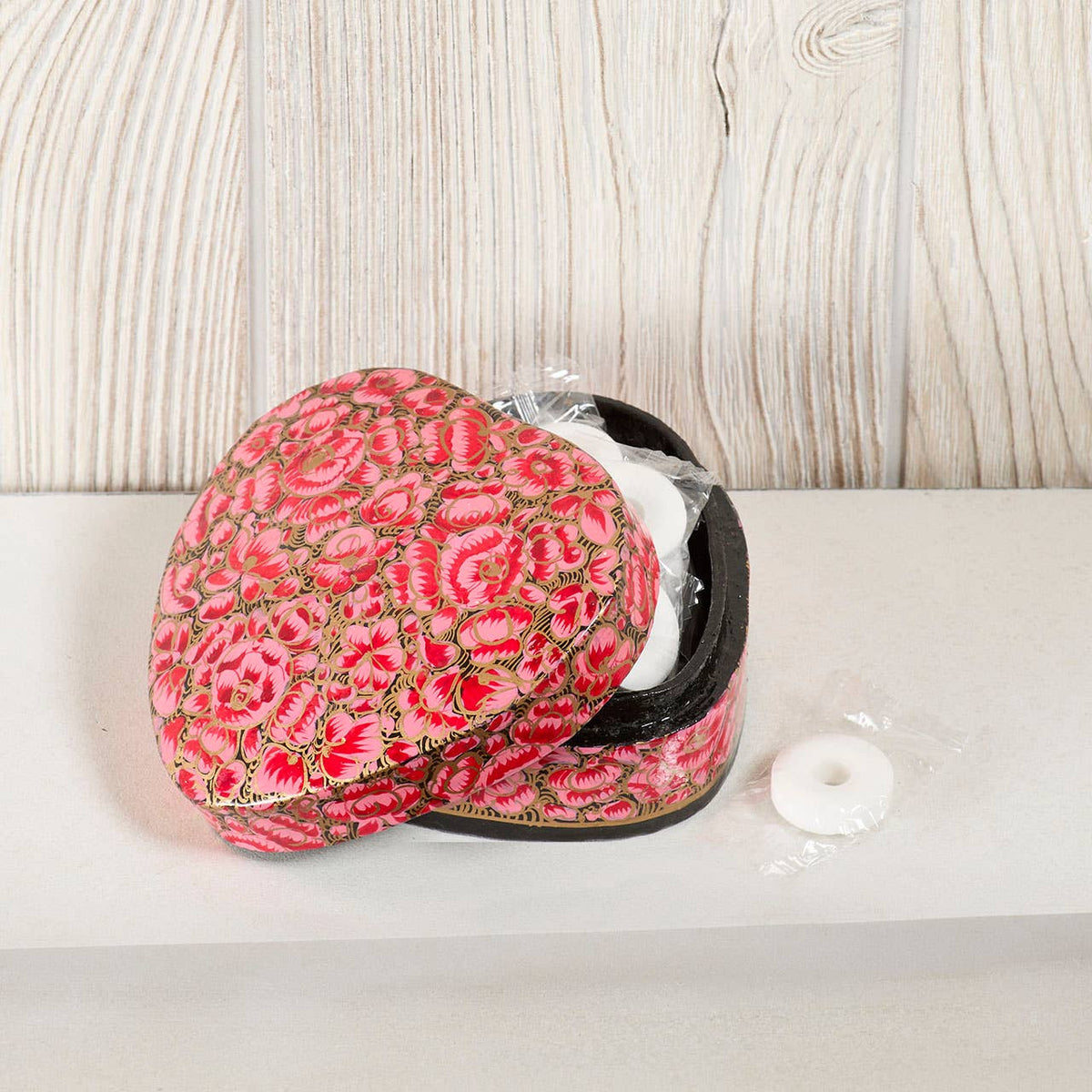 Open heart-shaped Beloved Heart Kashmiri Box - Pink featuring a pink and gold floral pattern and containing small white wrapped candies.