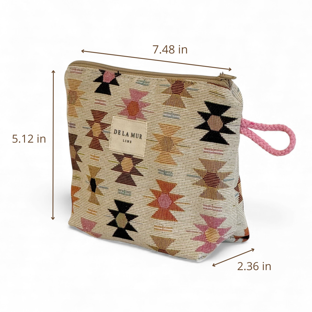 The Geometric Jacquard Small Makeup Bag – Pink & Orange (Royal) by DE LA MUR LINE US Inc features beige jacquard fabric adorned with Aztec-inspired geometric patterns, a vibrant pink rope handle, and the signature De La Mur label. Measuring 7.48 inches wide, 5.12 inches tall, and 2.36 inches deep, it’s perfect as a makeup pouch or chic accessory organizer.