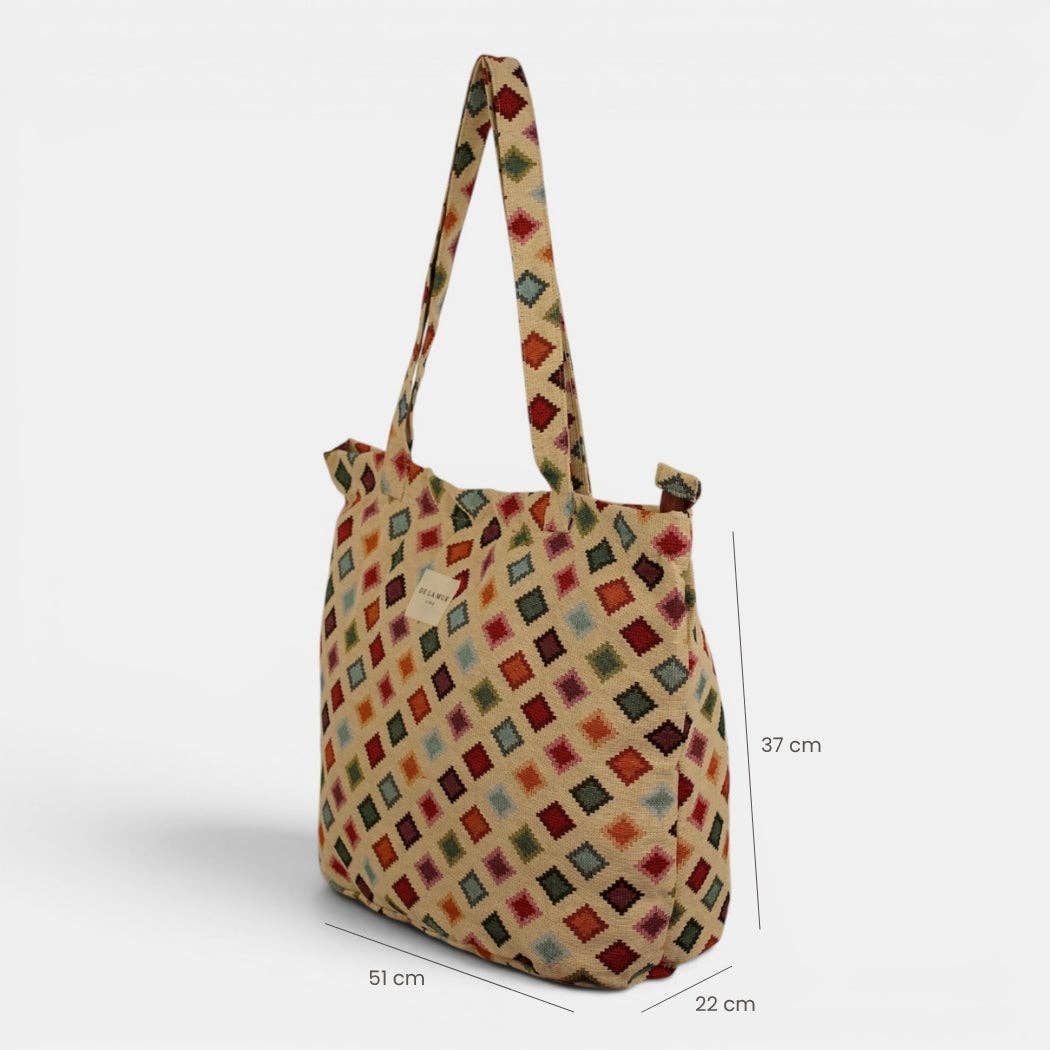Introducing the Geometric Jacquard Large Zippered Tote Bag – Multicolor (Zac) by DE LA MUR LINE US Inc, featuring an eye-catching geometric pattern with vibrant multicolor diamond shapes. Expertly crafted from jacquard fabric, this spacious tote is equipped with a secure zipper closure, two sturdy handles, and measures 51 cm wide, 37 cm tall, and 22 cm deep.
