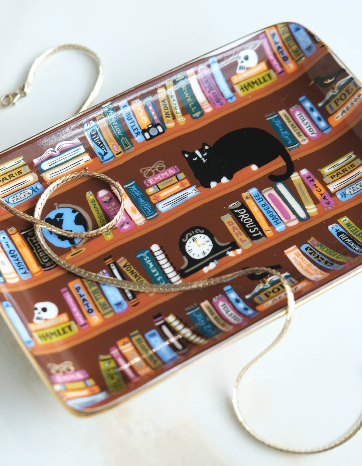 Rectangular Porcelain Trinket Tray - Bookshelves Library decorated with a pattern of bookshelves, classic book spines, and a black cat, perfect as a book lover gift.