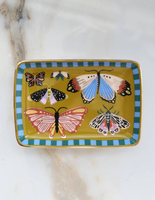 Idlewild Co. Porcelain Trinket Tray - Butterflies featuring a mustard yellow interior with five colorful illustrated moths, framed by a blue and green striped border with gold detailing.