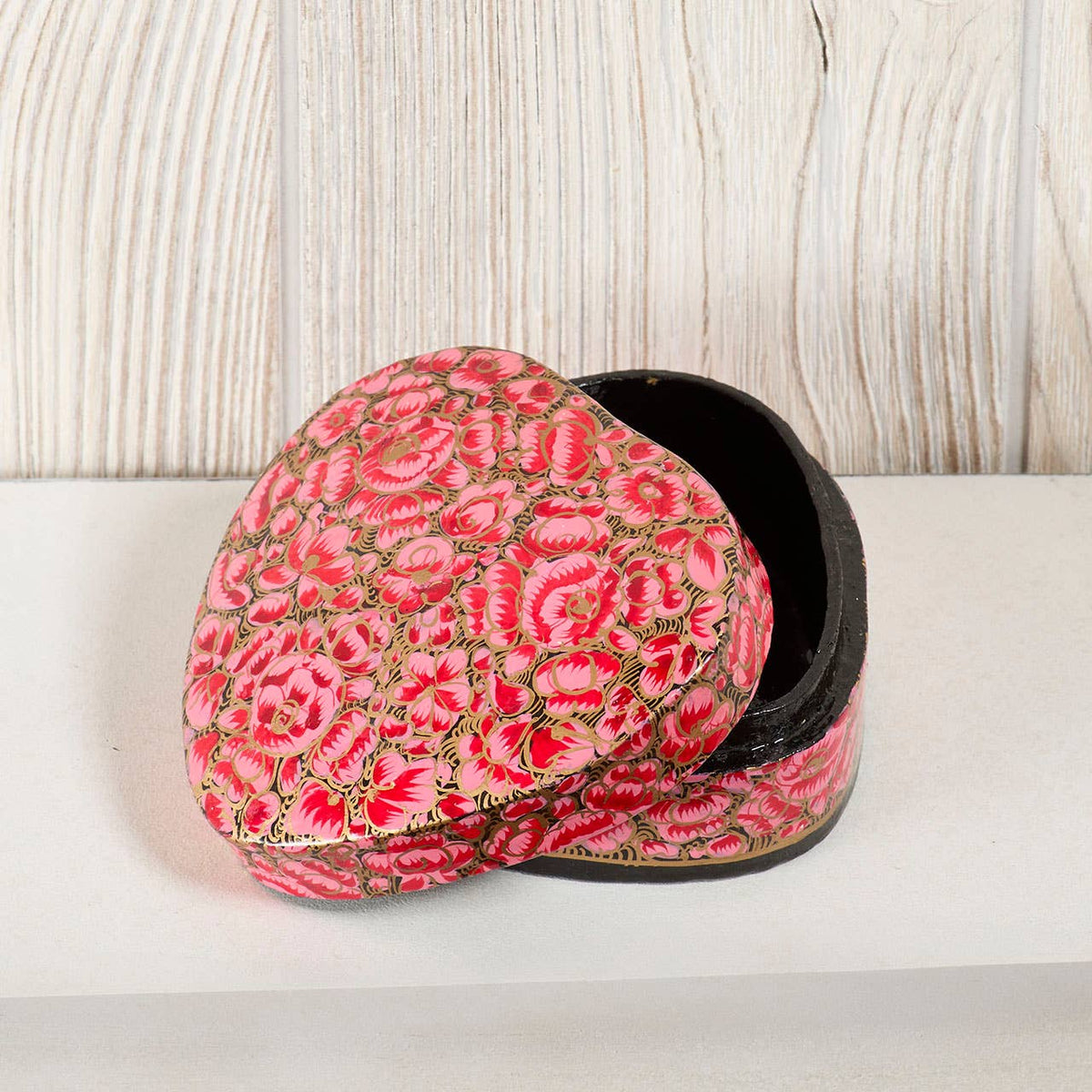 Beloved Heart Kashmiri Box - Pink, a heart-shaped hand-painted jewelry box with a pink and black floral pattern and a slightly opened lid.