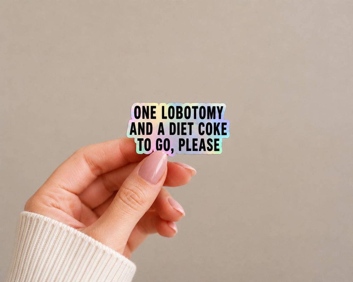 A hand with light pink nails holds the Funny Diet Coke Sticker - Lobotomy to go by Hello Brand | Sticker My Art against a plain beige background.