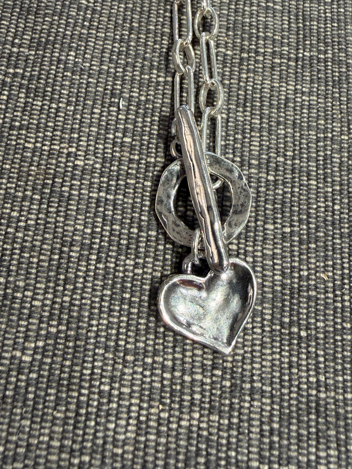 Dimpled Heart Necklace - Sterling featuring a hammered silver heart pendant on a sterling chain with a toggle clasp.