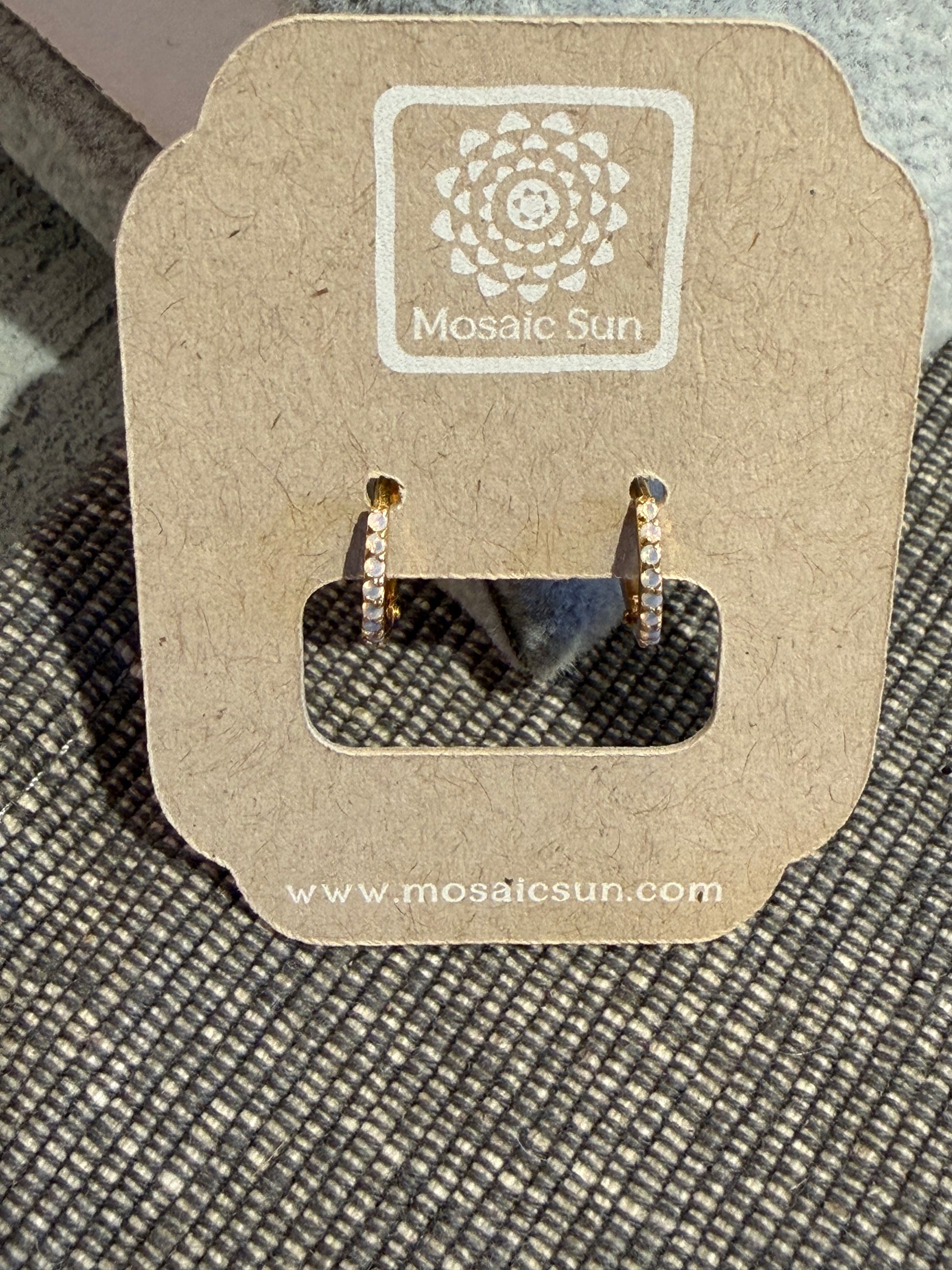A pair of PK Fine 14k Solid Gold Opalescent Clicker Hoops, featuring small gold hoops with inset white stones mounted on a branded cardboard display card.