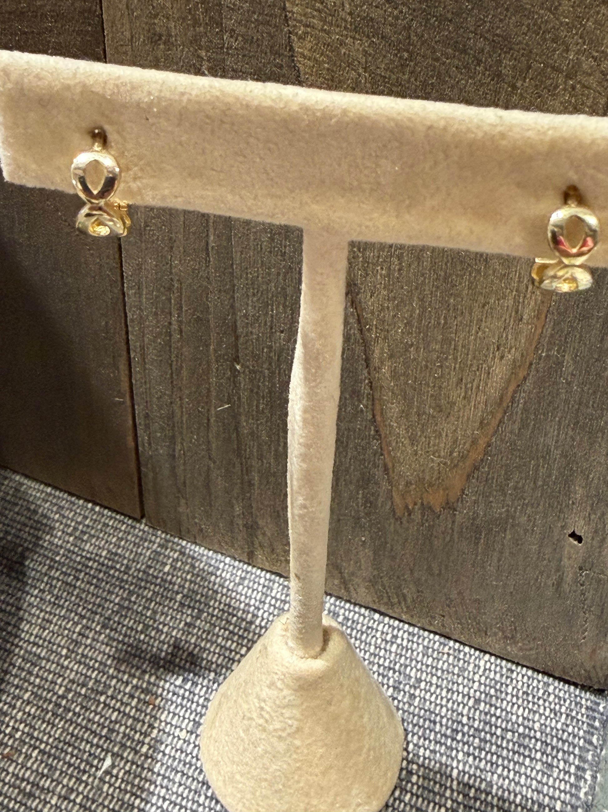 PK Fine 14k Solid Gold Unique Hoops featuring a small, stacked figure-eight design displayed on a stand.