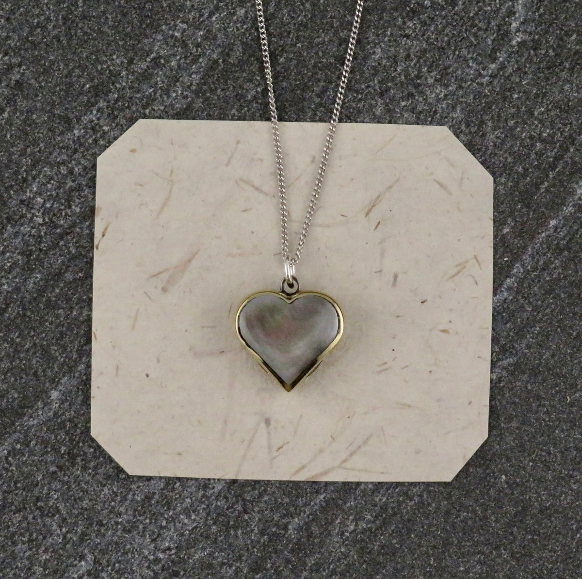 Blue Ridge Knives Mini Heart Knife Necklace: a sterling silver curb chain with a heart-shaped pendant featuring a grey iridescent abalone shell inlay.