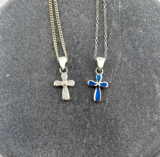 Sterling silver lab opal cross pendant on a sterling silver chain, displayed on a textured grey background.
