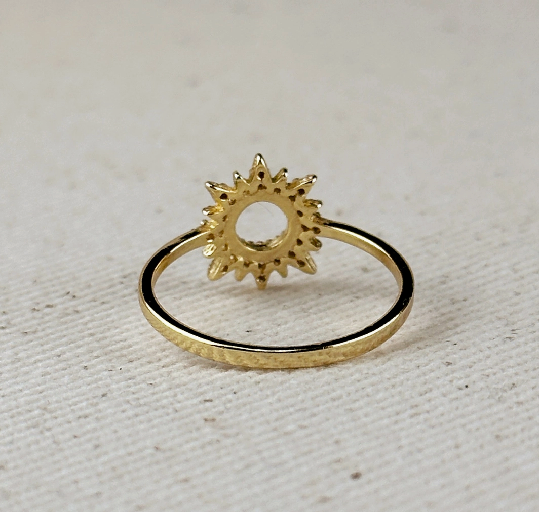 The GoldFi Gold Filled CZ Open Starburst Ring features a delicate, gold-filled band with a starburst design that has shimmering pointed rays and an open circular center.