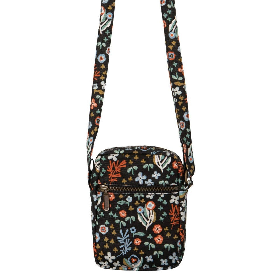 Danica Studio Dogwood Cotton Crossbody Bag in black with a colorful floral pattern and an adjustable strap.