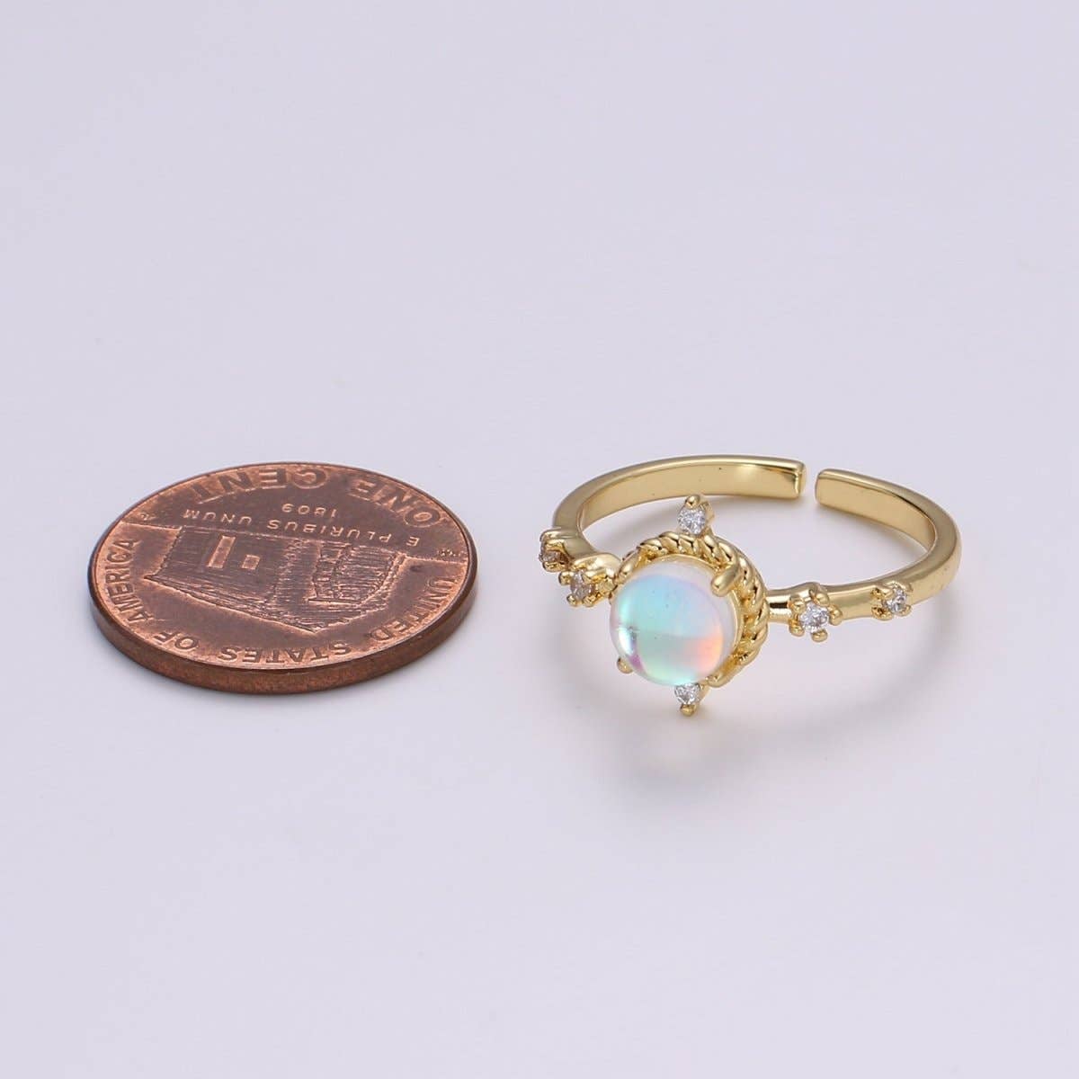 Aim Eternal Opalescent Moonstone Gem Ring GF - Adjustable gold-tone ring with a round moonstone and clear crystal accents, shown next to a penny for scale.