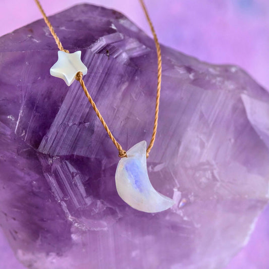 SoulKu’s Moonstone I Love You To The Moon & Back Necklace featuring a crescent moon charm and a small mother-of-pearl star, displayed on a large purple crystal.