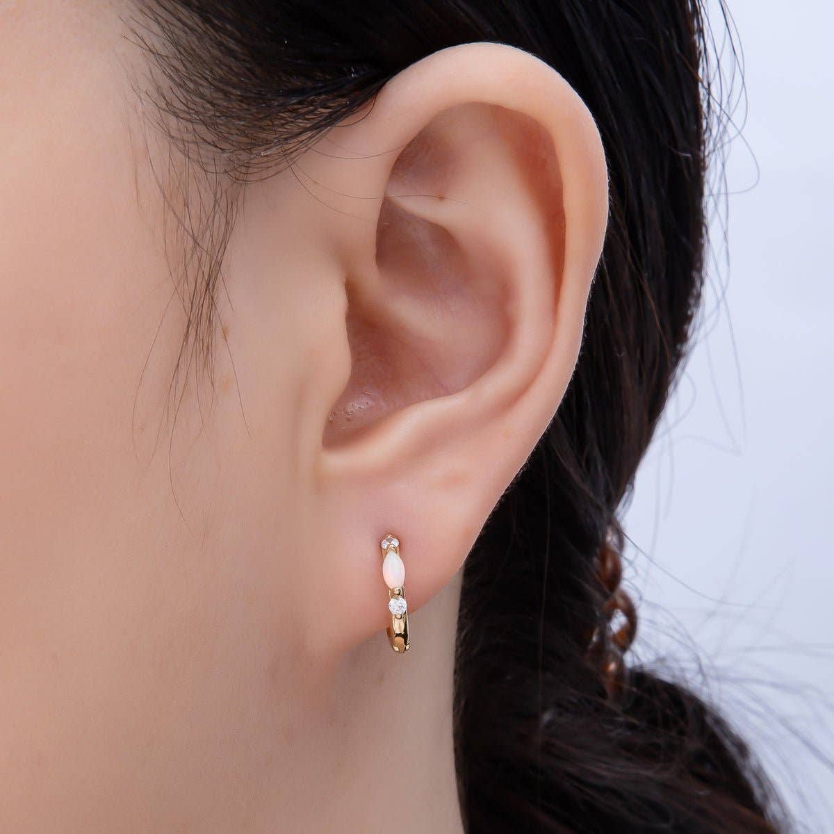 Aim Eternal Gold Filled 13mm White Opal/CZ Huggie Hoops, featuring a white opal stone and a small cubic zirconia, worn in an earlobe.