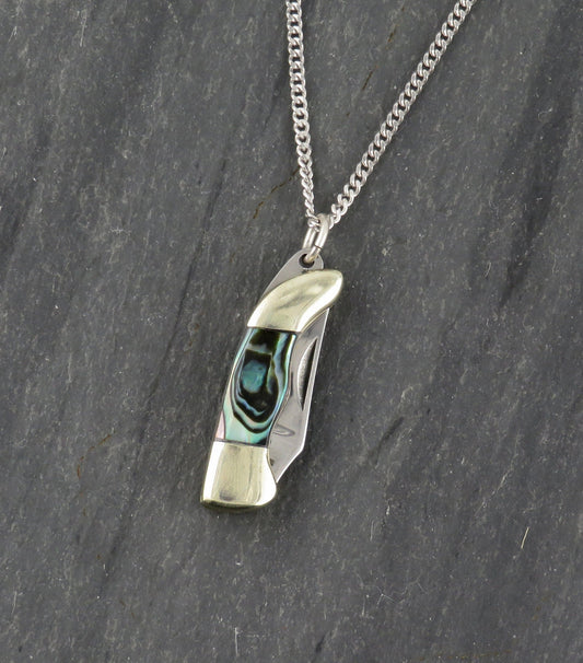 The Abalone Mini Knife Necklace - Medium by Blue Ridge Knives features a curved, rectangular pendant with a abalone shell inlay, suspended from a delicate sterling silver chain.